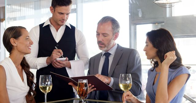 Business colleagues ordering meals at elegant restaurant - Download Free Stock Images Pikwizard.com