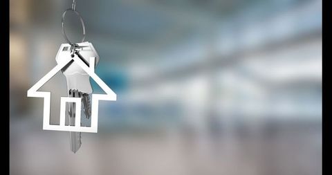 House-Shaped Keychain Holding Keys in Modern Blurred Lobby