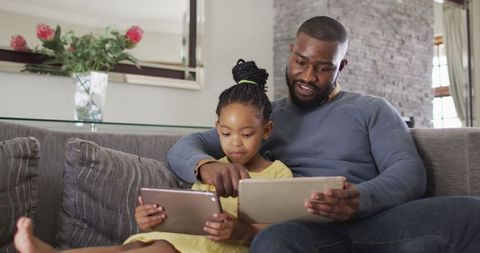 Father and Daughter Bonding with Tablets in Living Room