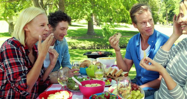 Friends Enjoying Picnic Lunch in Sunny Park - Download Free Stock Images Pikwizard.com