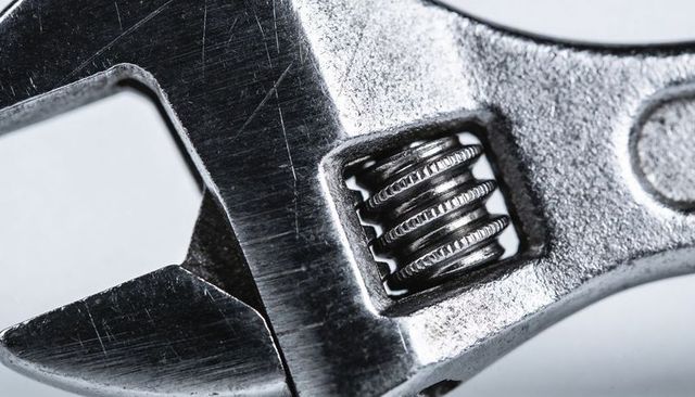 Macro adjustable wrench featuring worm gear and open jaw with scratched metal texture