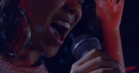 Energetic Performer Singing Enthusiastically into Microphone with Stars