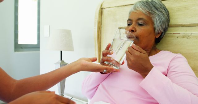 Elderly Woman Receiving Glass of Water in Bed - Download Free Stock Images Pikwizard.com