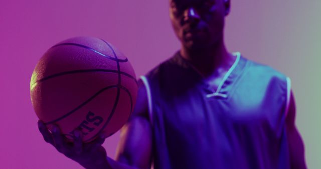 Image of african american male basketball player bouncing ball on purple background. Sports and competition concept.