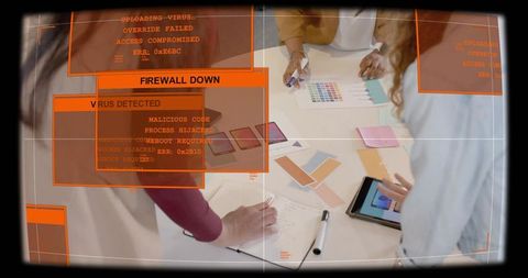 Designers collaborating on color palette and tablet with cyber security alert overlay