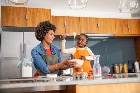 Mother and Daughter Enjoy Whisking Batter in Modern Kitchen