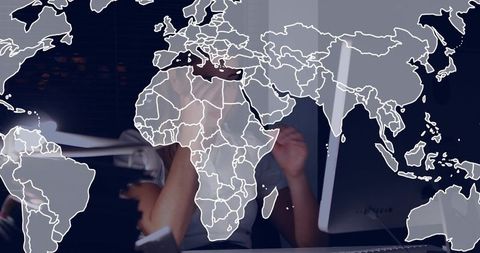 Businesswoman Working at Desk with World Map Overlay for Global Strategy and Remote Teams