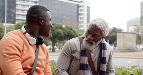 African American Men Sharing Conversation on Urban Park Bench, Generational Friendship