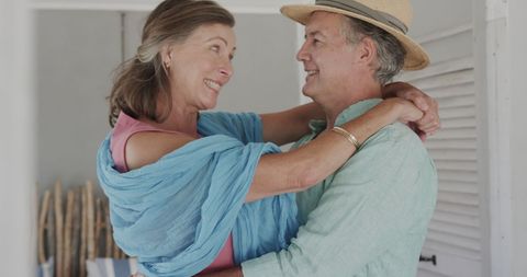 Senior Couple Embracing Indoors with Happiness