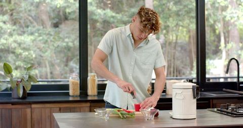 Man preparing meal with fresh veggies in bright kitchen