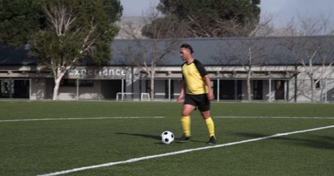 Focused youth soccer player controlling ball on field action shot