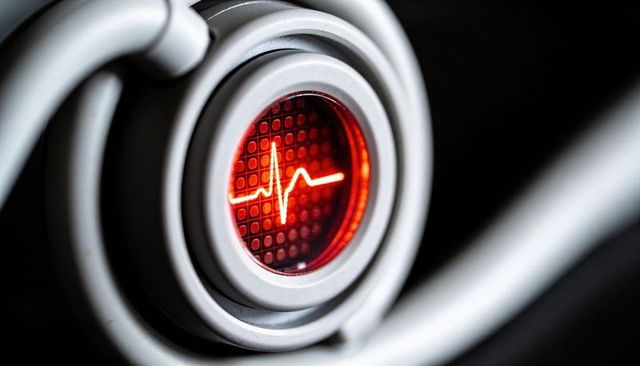 Pulsating red ekg pulse indicator on glossy circular bezel macro industrial control panel