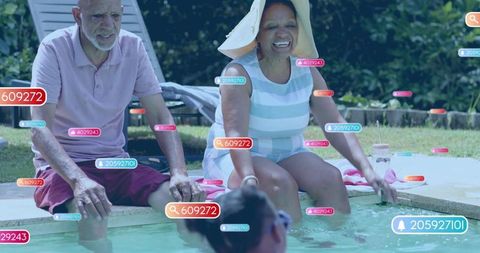 Senior couple relaxing at backyard pool with digital user interface tags and family fun
