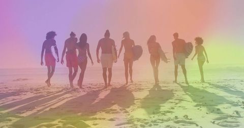 Eight Surfers Walking Toward Ocean Carrying Surfboards Backlit Beach Silhouettes