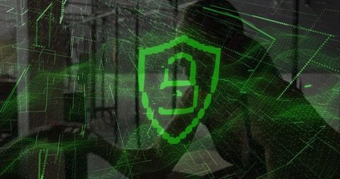 Silhouette woman typing on laptop with green holographic cybersecurity shield overlay