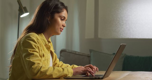 Young woman working on laptop at home in cozy living room - Download Free Stock Images Pikwizard.com