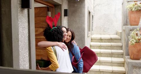 Diverse Friends Sharing Warm Hug Home Entrance Celebratory Atmosphere