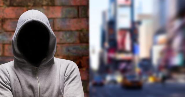 Mysterious figure in hooded sweatshirt blending into busy city background. Useful for illustrating concepts related to crime, anonymity, security threats, urban unrest, secrecy and mysterious identities in fast-paced urban environments.