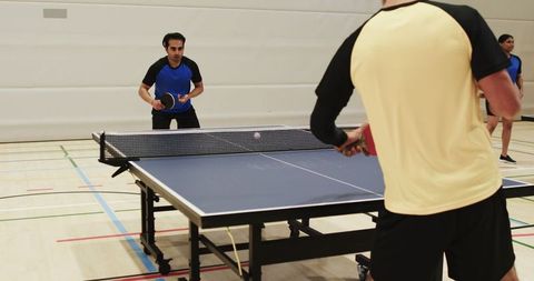 Diverse Friends Enjoying Table Tennis in Sports Hall