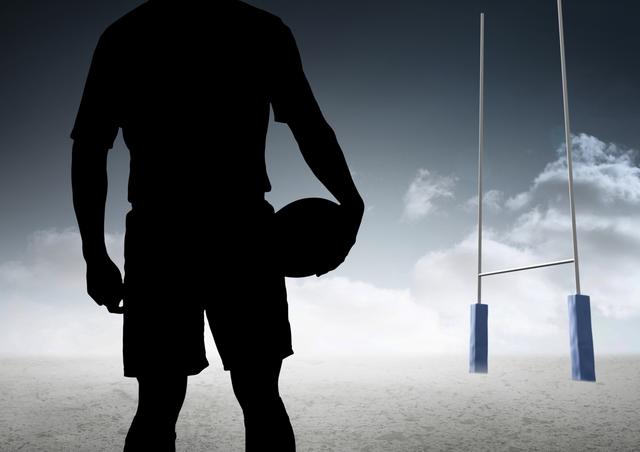 Digital composite image of silhouette athlete standing with rugby ball