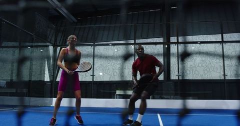 Young diverse athletes playing padel on blue turf court