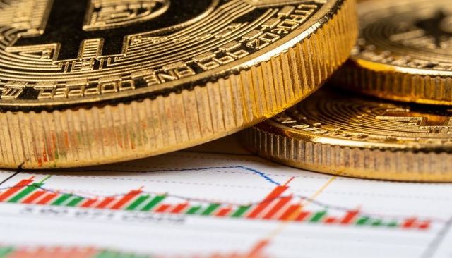 Closeup gold bitcoin coins stacking on crypto trading chart with candlestick trends