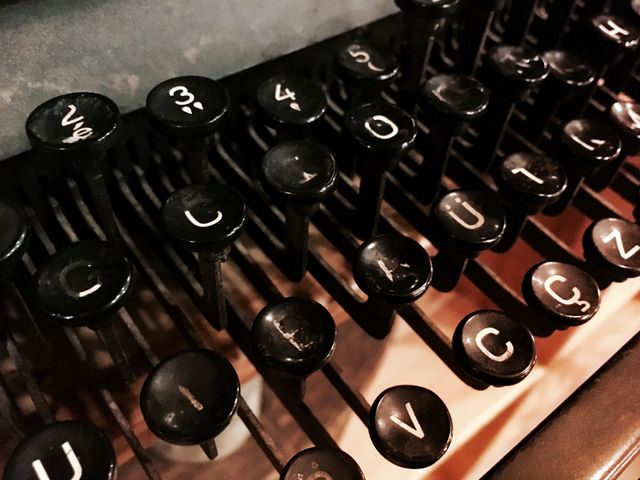 Close-up view of intricate vintage typewriter keys. Perfect for use in articles or advertisements about writing, history, vintage items, or technological evolution. Great for blogs and social media posts focusing on nostalgia and the beauty of outdated technology.