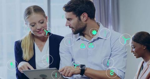 Business team reviewing tablet with augmented reality sustainability and finance icons