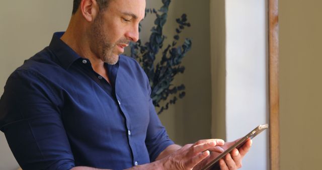 Businessman using tablet by window in modern office - Download Free Stock Images Pikwizard.com