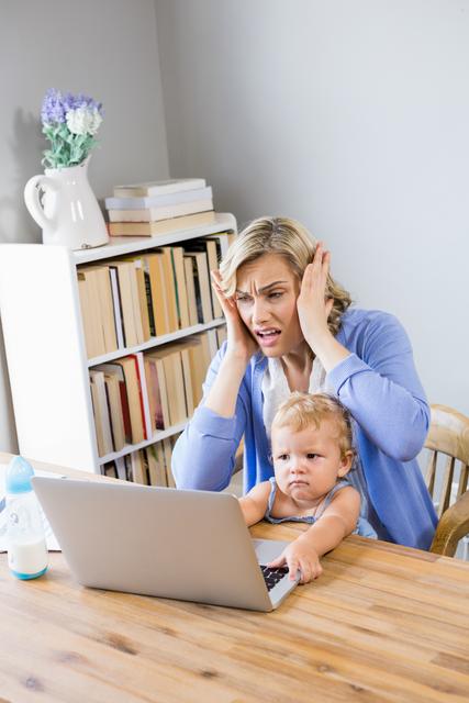 Stressed Mother with Baby Using Laptop at Home - Download Free Stock Photos Pikwizard.com