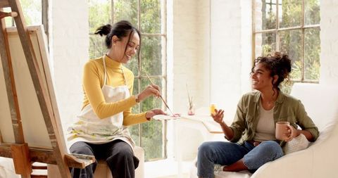 Creative Women Relaxing with Art in Bright Studio