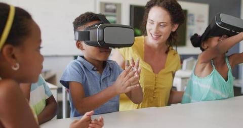 Teacher guiding children using VR headsets in classroom - Download Free Stock Images Pikwizard.com