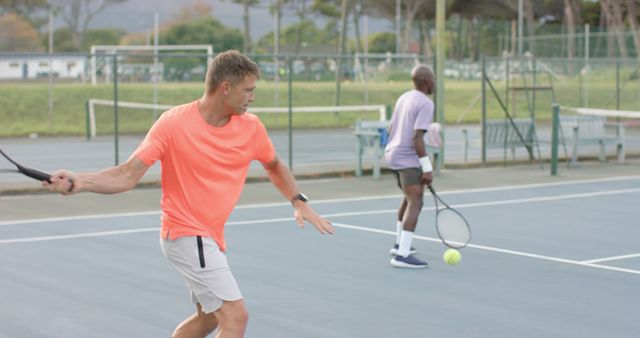 Two Men Playing Tennis on Outdoor Court with Focused Expressions - Download Free Stock Images Pikwizard.com