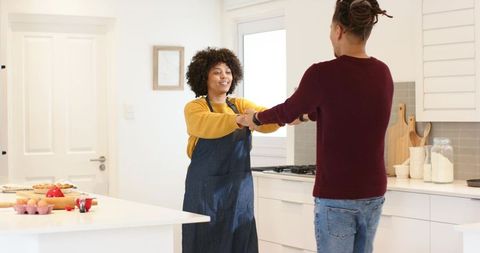 Holding hands and baking together in bright modern kitchen, cozy lifestyle moment