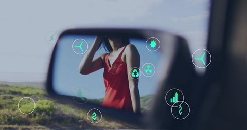 Shielding woman in red dress reflecting in car mirror with eco icons promoting eco travel