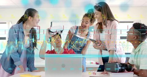 Teenagers exploring VR technology in collaborative STEM classroom with laptop and gadgets