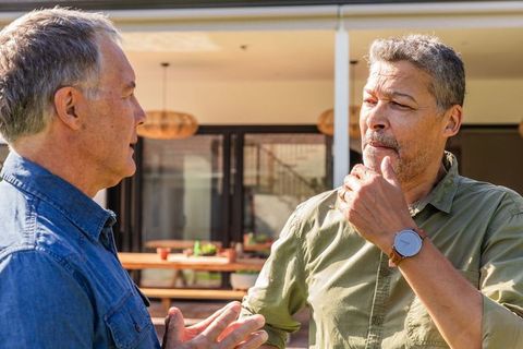 Mature Men Enjoy Relaxed Conversation on Sunny Patio