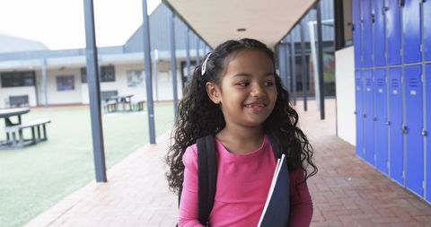 Young Hispanic Girl Smiling in School Courtyard Holding Notebook - Download Free Stock Images Pikwizard.com