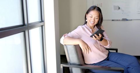 Business Professional Conversing on Smartphone by Office Window