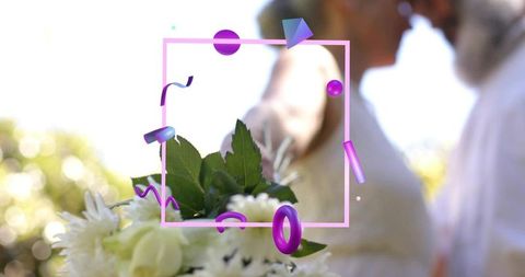Sunlit outdoor wedding bouquet featuring blurred couple, pink frame and purple confetti