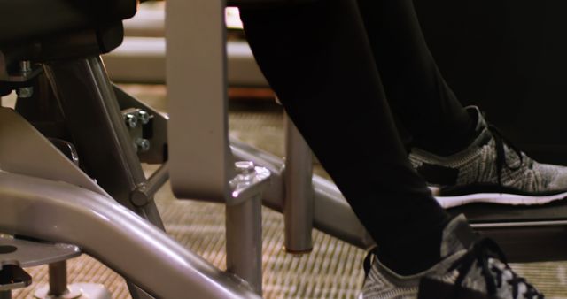 Person exercising legs at gym with fitness equipment - Download Free Stock Images Pikwizard.com