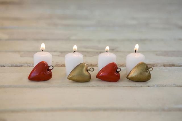 Burning Candles with Heart Decorations on Wooden Plank - Download Free Stock Photos Pikwizard.com