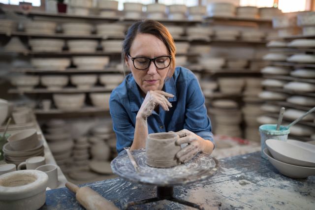 Female potter molding a clay in pottery workshop