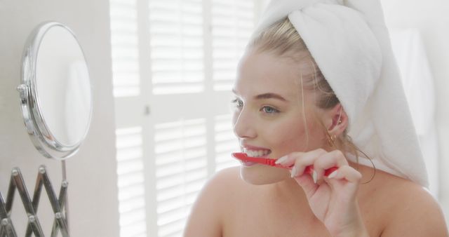 Smiling Woman Brushing Teeth with Red Toothbrush in Bathroom - Download Free Stock Images Pikwizard.com