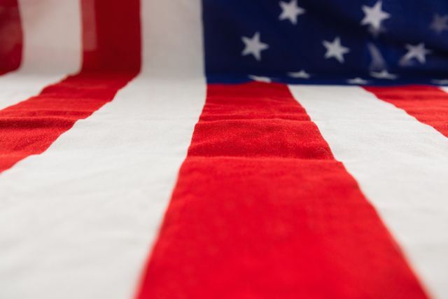 This close-up of the American flag highlights the vibrant red, white, and blue colors, making it perfect for use in patriotic-themed projects, educational materials, or as a background for events celebrating American holidays such as Independence Day, Memorial Day, and Veterans Day.