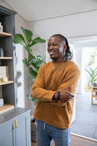 Smiling Man in Casual Outfit Relaxing at Modern Home with Plants