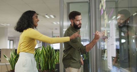 Diverse Team Brainstorming on Office Glass Wall