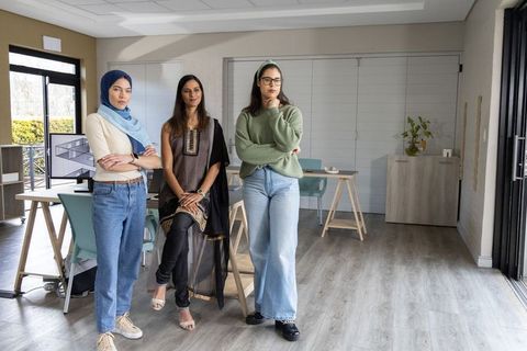 Multicultural female team collaborating in modern office, showcasing teamwork and creativity