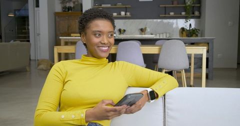 Smiling Woman Relaxing with Smartphone at Home