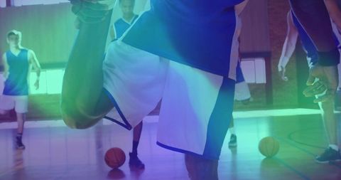 Stretching male basketball player pulling foot during team warmup on hardwood court